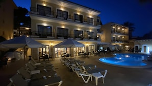 A hotel with a pool, sun loungers, umbrellas, and outdoor seating. - Hostal Villa Rosa (Calvia)