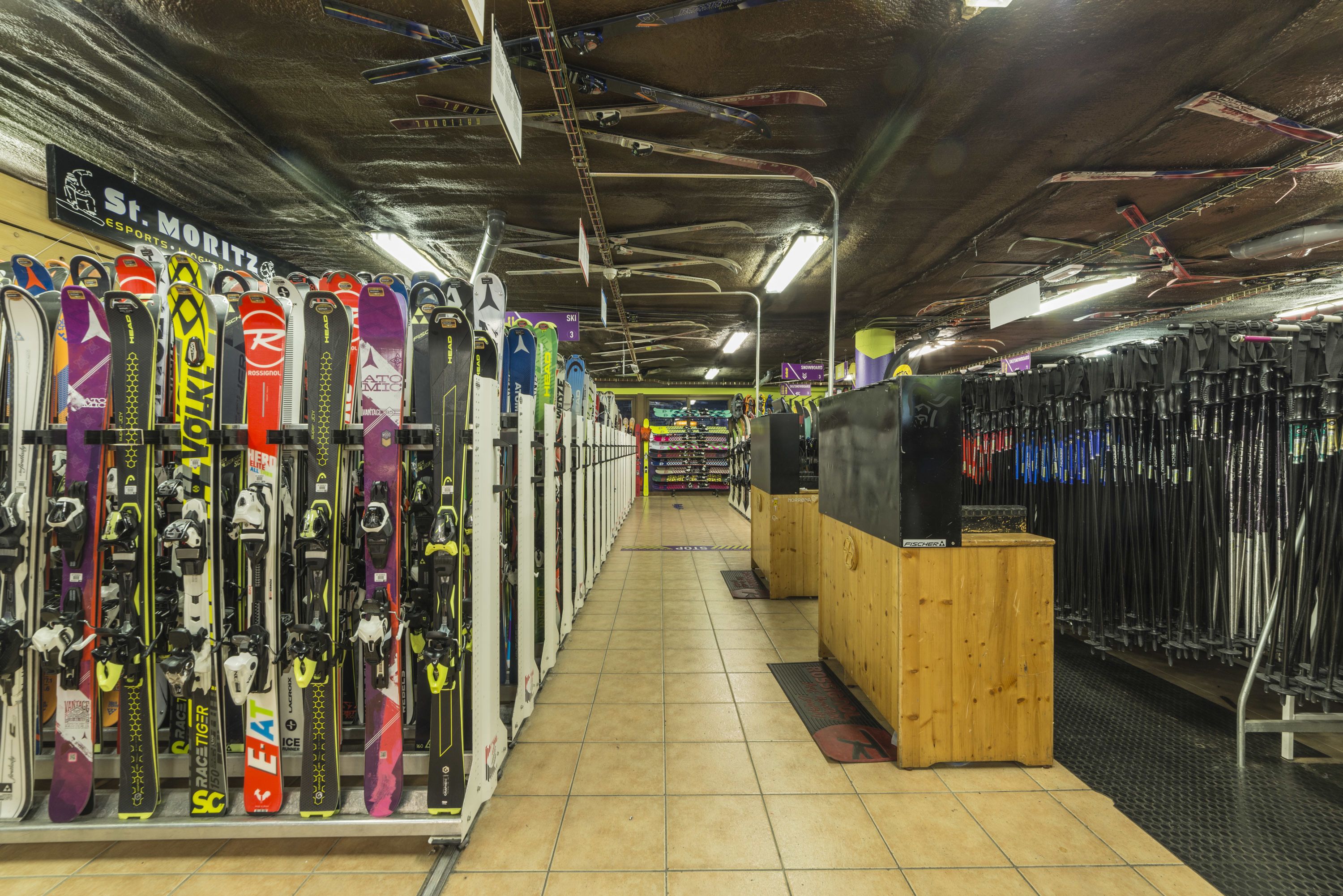 A ski equipment store with rows of skis and snowboards on display.