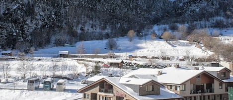 A snow-covered mountain town with a prominent building featuring a balcony and signage.