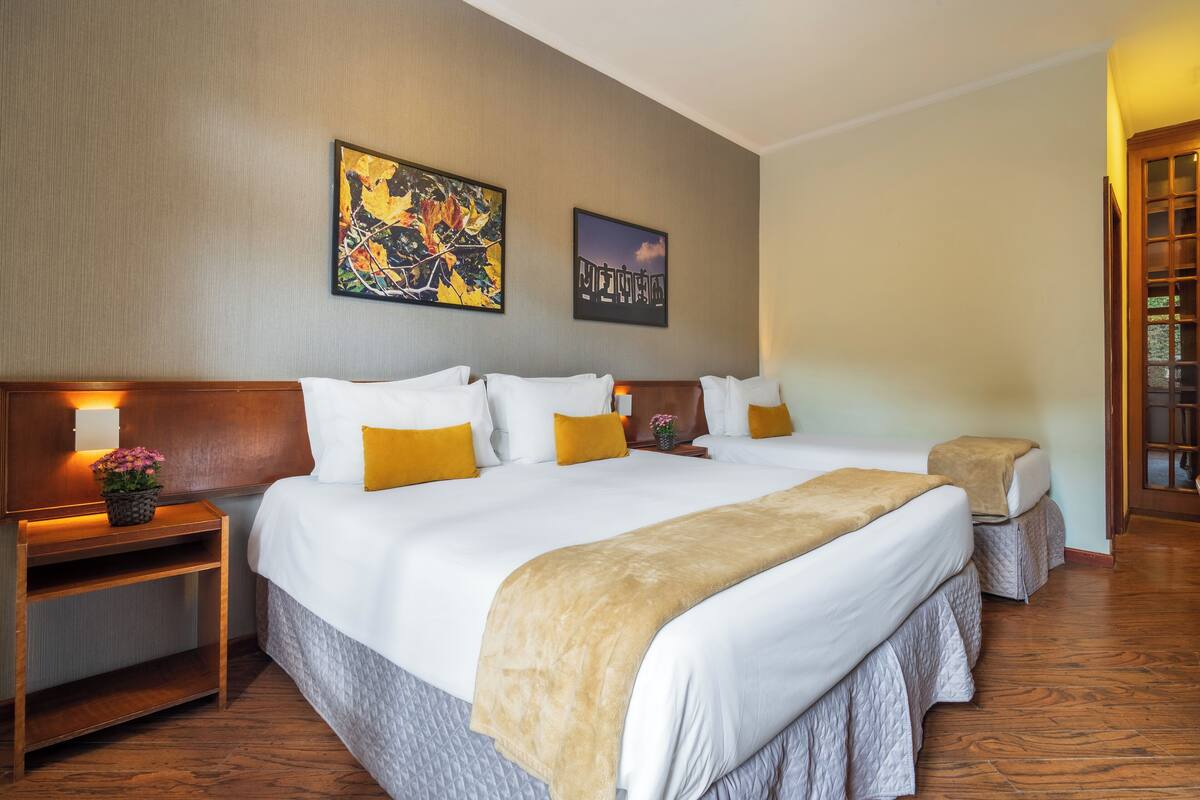 Een hotelkamer met een groot bed, twee nachtkastjes en een nachtkastje met een lamp.