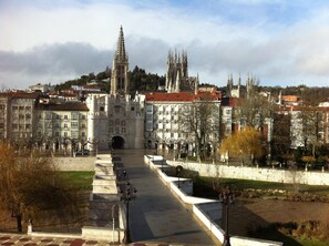A grand cathedral with a tall spire, a large central doorway, and a symmetrical facade. - Hotel Via Gotica (Burgos)