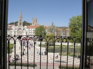 A view of a plaza with a river, a cathedral, and people walking. - Hotel Via Gotica (Burgos)