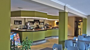 Ein Restaurant mit Theke und Sitzbereich, einschließlich Tischen und Stühlen.