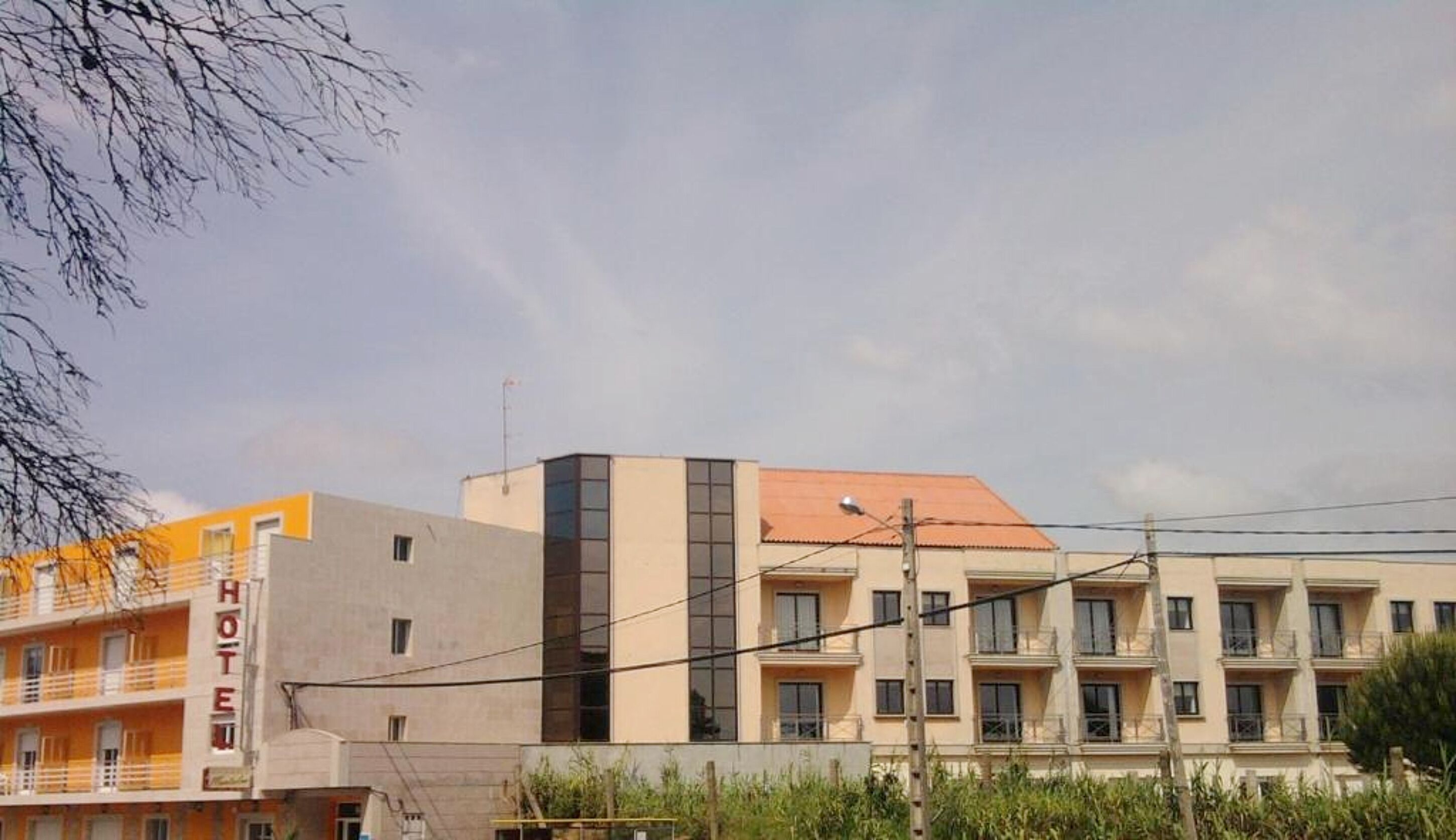 Ein Hotel mit mehreren Etagen, Balkonen und einem Flachdach.