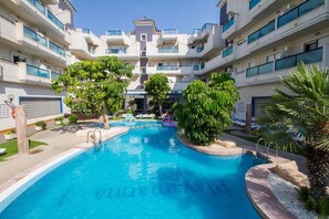 Piscine extérieure, parasols de plage, chaises longues