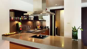 A modern kitchen with a granite countertop, stainless steel appliances, and wooden cabinetry.