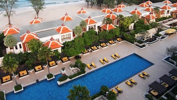 Relax by the central pool surrounded by sun loungers and shaded areas, with stunning views of the beach from your balcony.