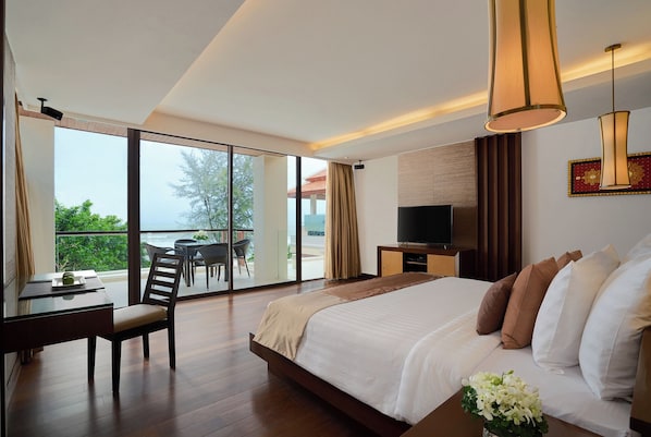 Une chambre d’hôtel avec un grand lit, une télévision, un bureau avec une chaise et un balcon équipé d’une table et de chaises.