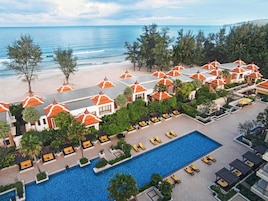 Un resort con piscina, playa y vista al océano.
