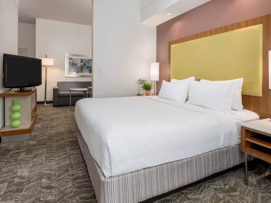 Una camera d'albergo con un letto grande, una televisione, una scrivania e una sedia.