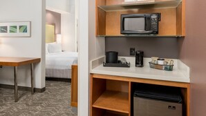 A hotel room with a bed, a desk, a microwave, a coffee maker, and a mini fridge. - SpringHill Suites by Marriott Lafayette South at River Ranch (Lafayette)