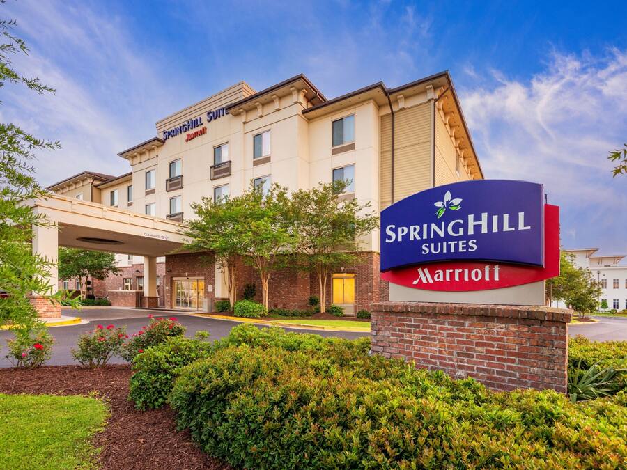 En hotellentrén med en skylt för SpringHill Suites Marriott, med en fasad av tegel och en överbyggd gångväg.