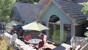 Eine Terrasse mit Tisch und Stühlen, ein Schild für reservierte Parkplätze und ein weißer Zaun.