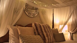 Ein Bett mit mehreren Kissen und einem Baldachin.