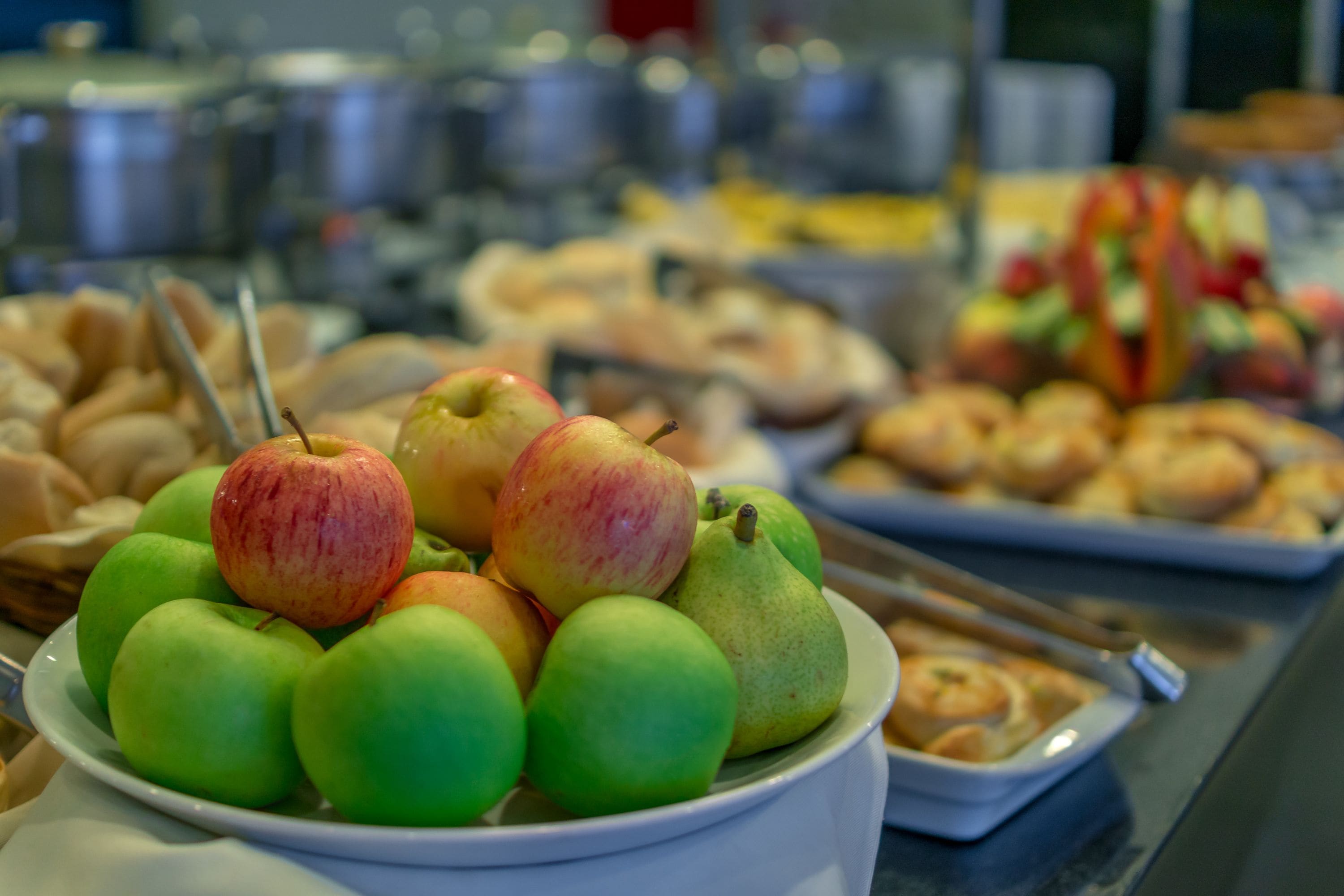 Un bufé con diversas frutas y pasteles.