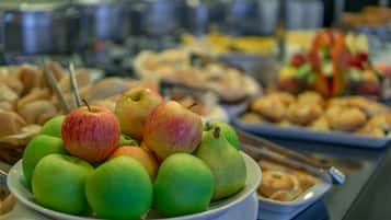 Un bufé con diversas frutas y pasteles.