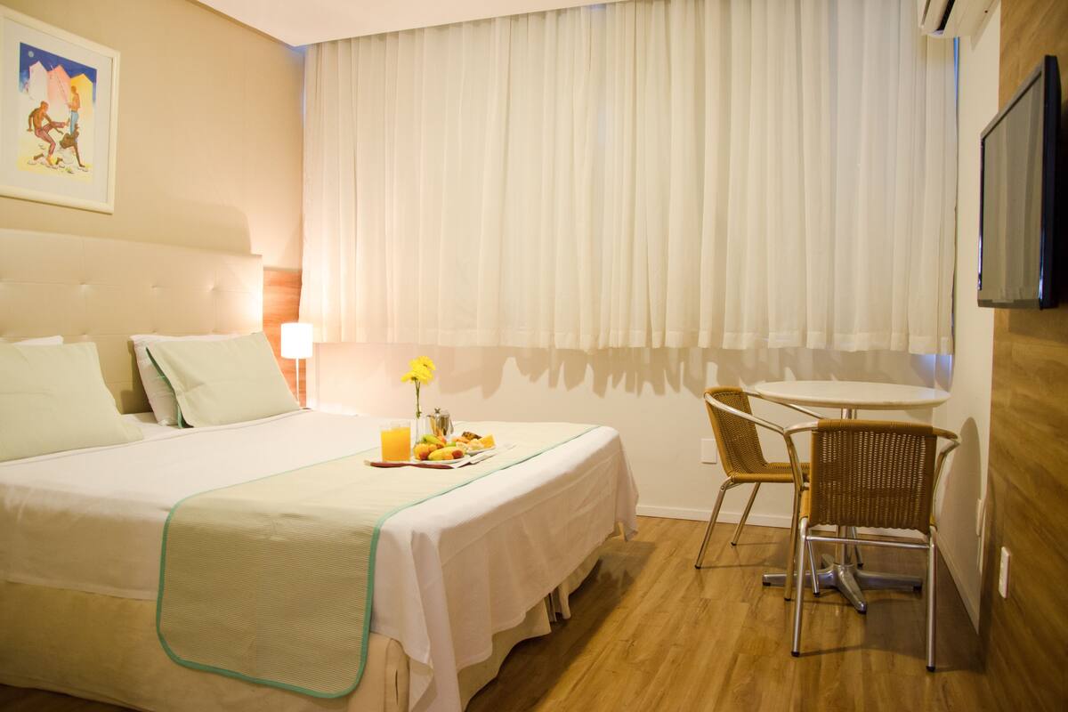 Een hotelkamer met een bed, een eettafel en een televisie.