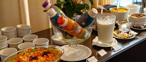 A buffet setup with various food items and beverages.