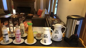 A coffee station with various drink dispensers labeled with different beverages like 'vanilla,' 'water,' 'leche,' and 'hot milk.' - Hostería Senderos (El Chalten)