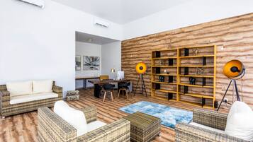 Una sala de estar moderna con muebles de mimbre, un panel de madera decorativo y un espacio de trabajo.