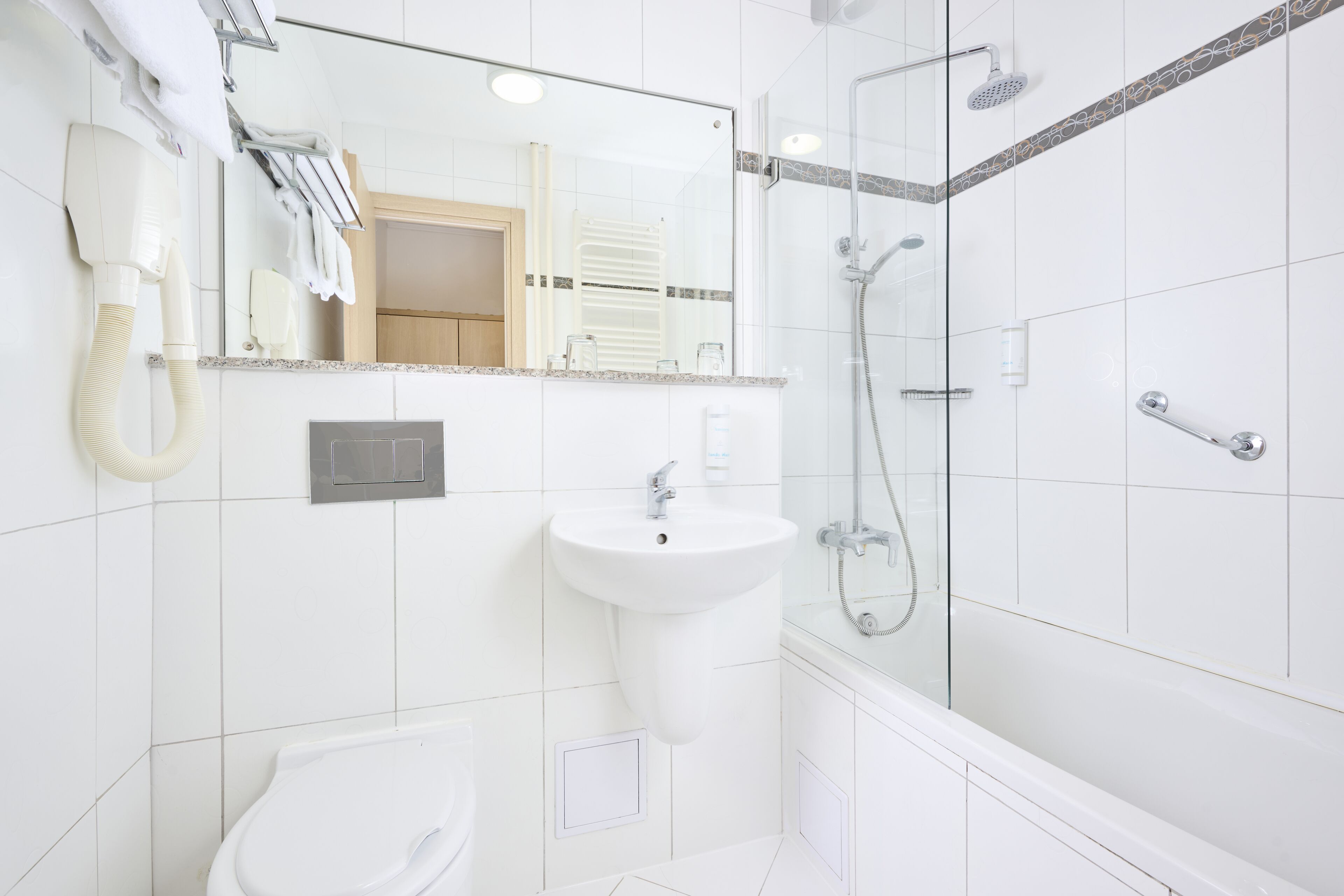 A modern bathroom with a white sink, a toilet, and a glass-enclosed shower area.