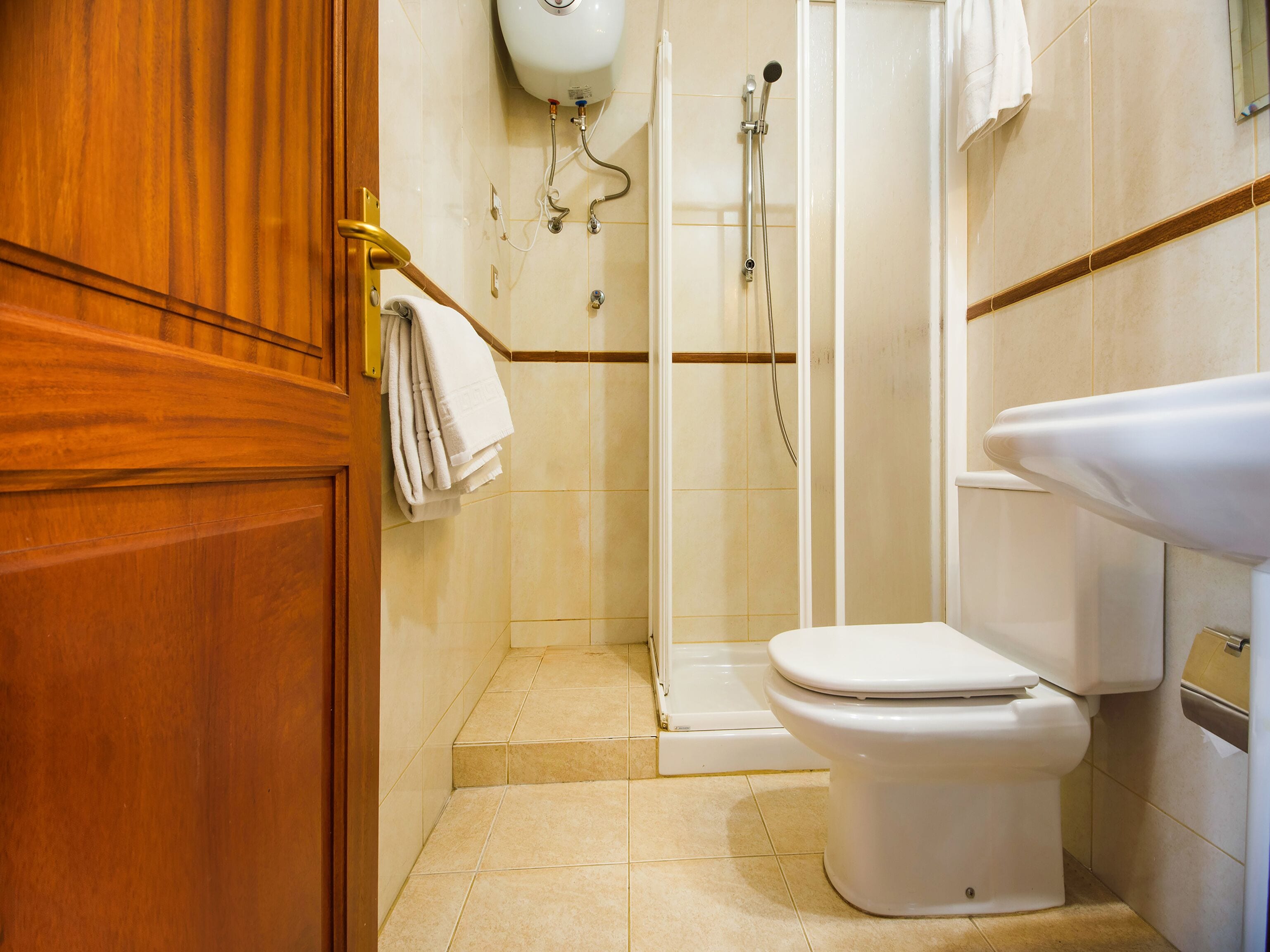 A bathroom with a toilet, a shower, and a sink.