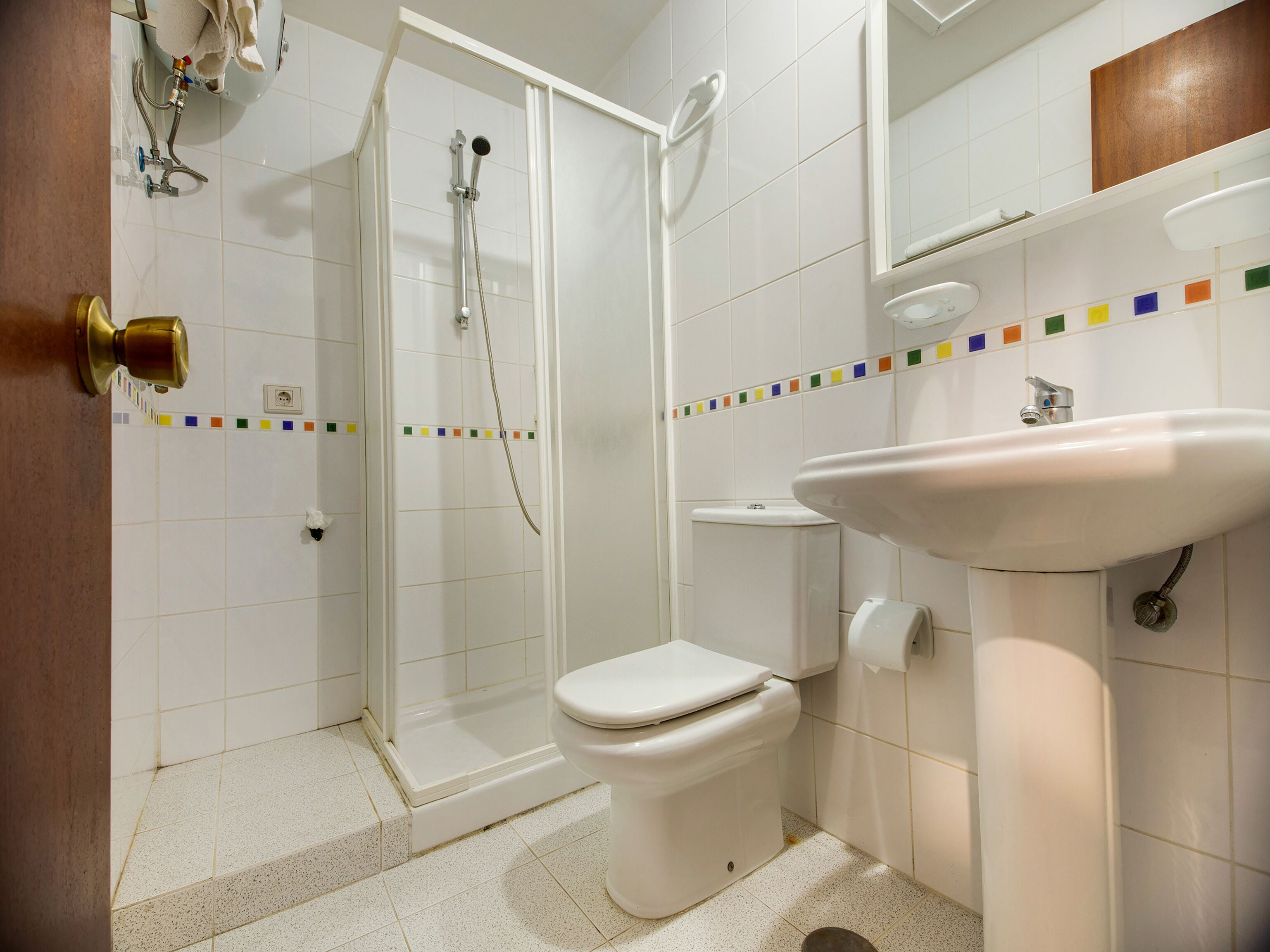 A bathroom with a shower, toilet, and sink.