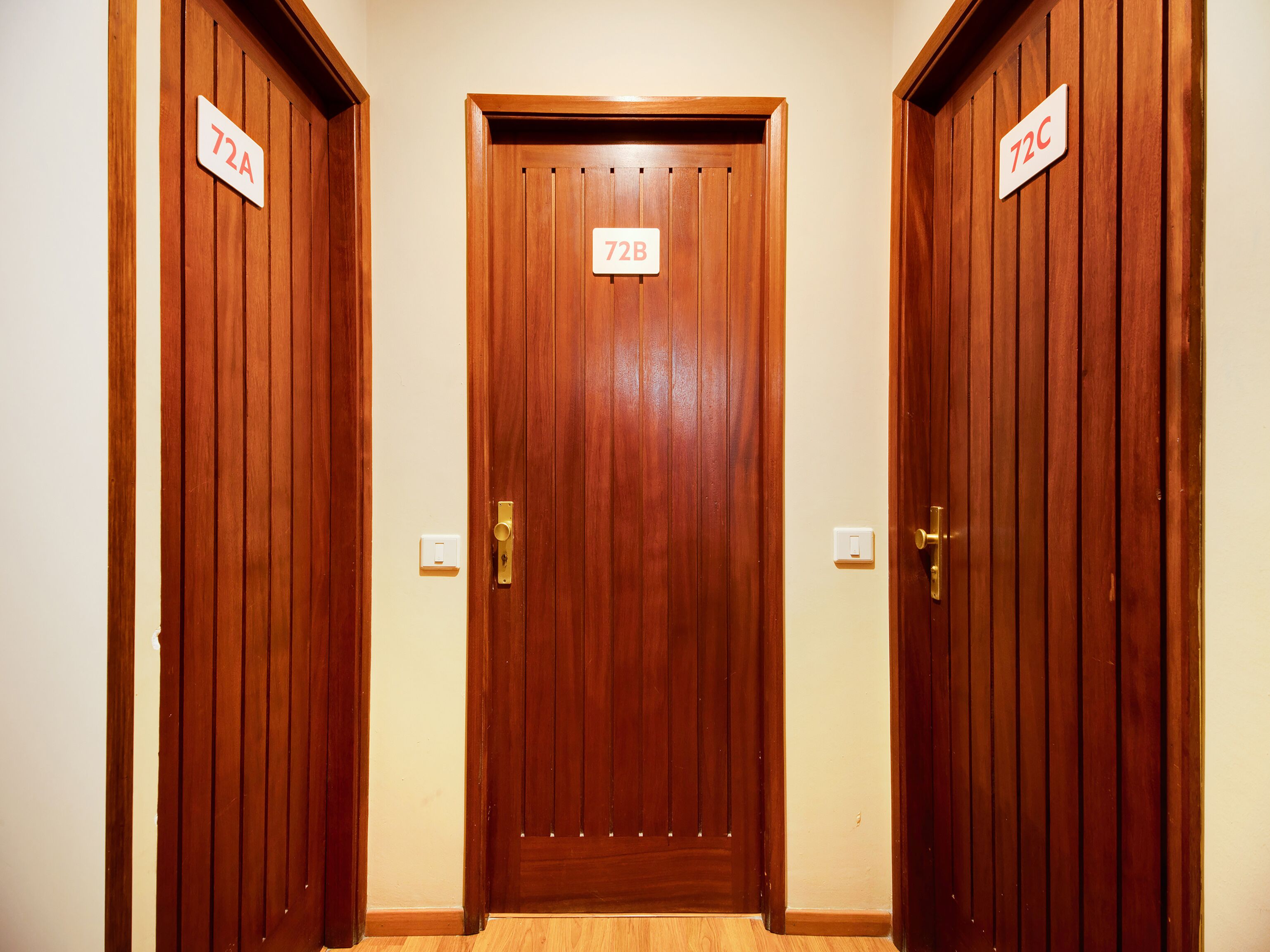 Three wooden doors with room numbers 72A, 72B, and 72C.