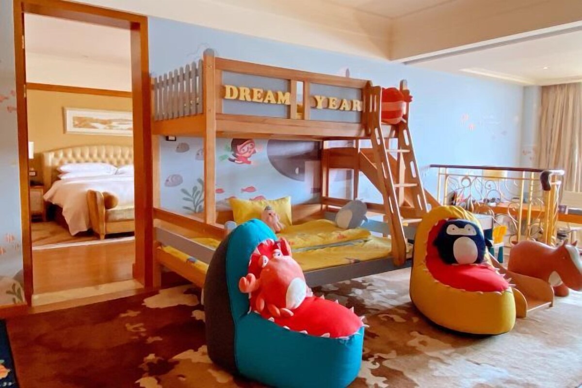Una habitación infantil con literas, una escalera y peluches.