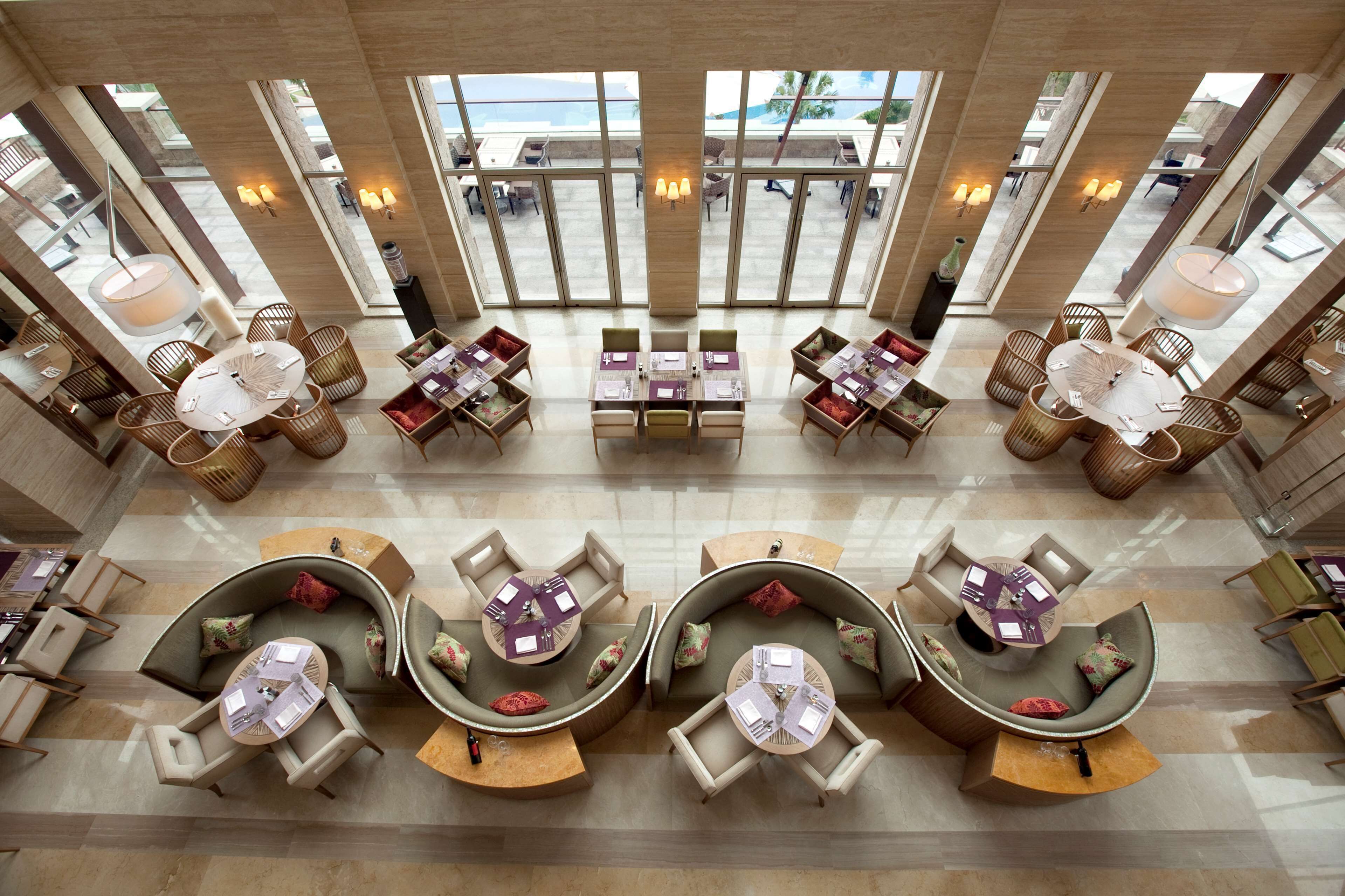 A spacious lobby with multiple seating areas, large windows, and a modern design.