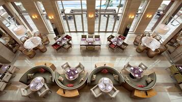 A spacious lobby with multiple seating areas, large windows, and a modern design.