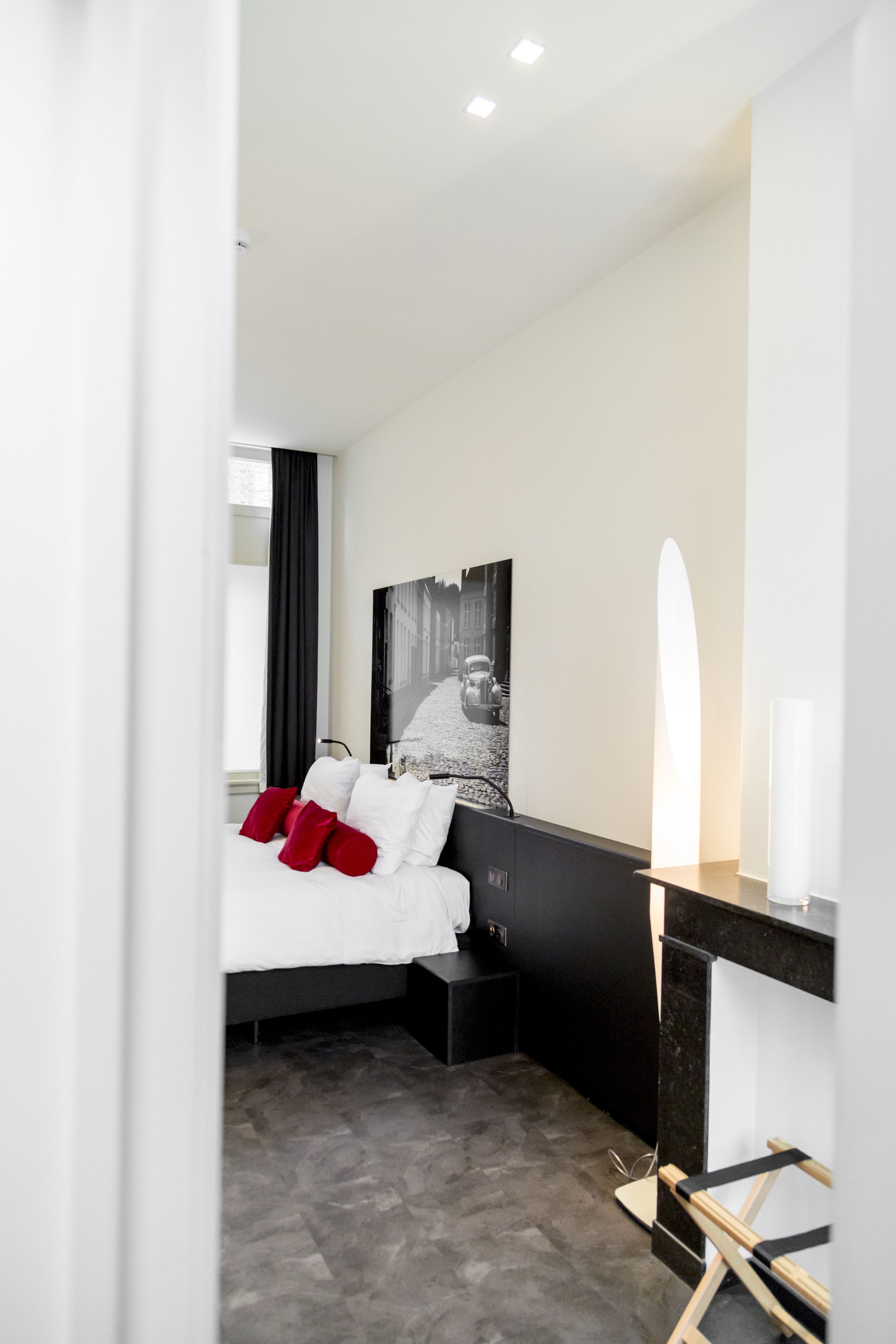 Habitació d'hotel moderna amb llit, escriptori i un gran mirall.