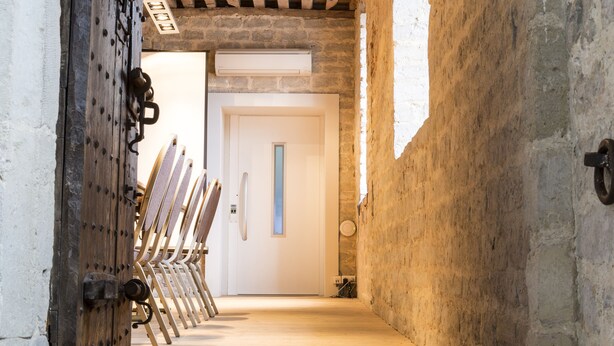 A narrow wooden staircase leading to a room with a white door and a wooden ceiling. - Zimmerhof Hotel (Lier)