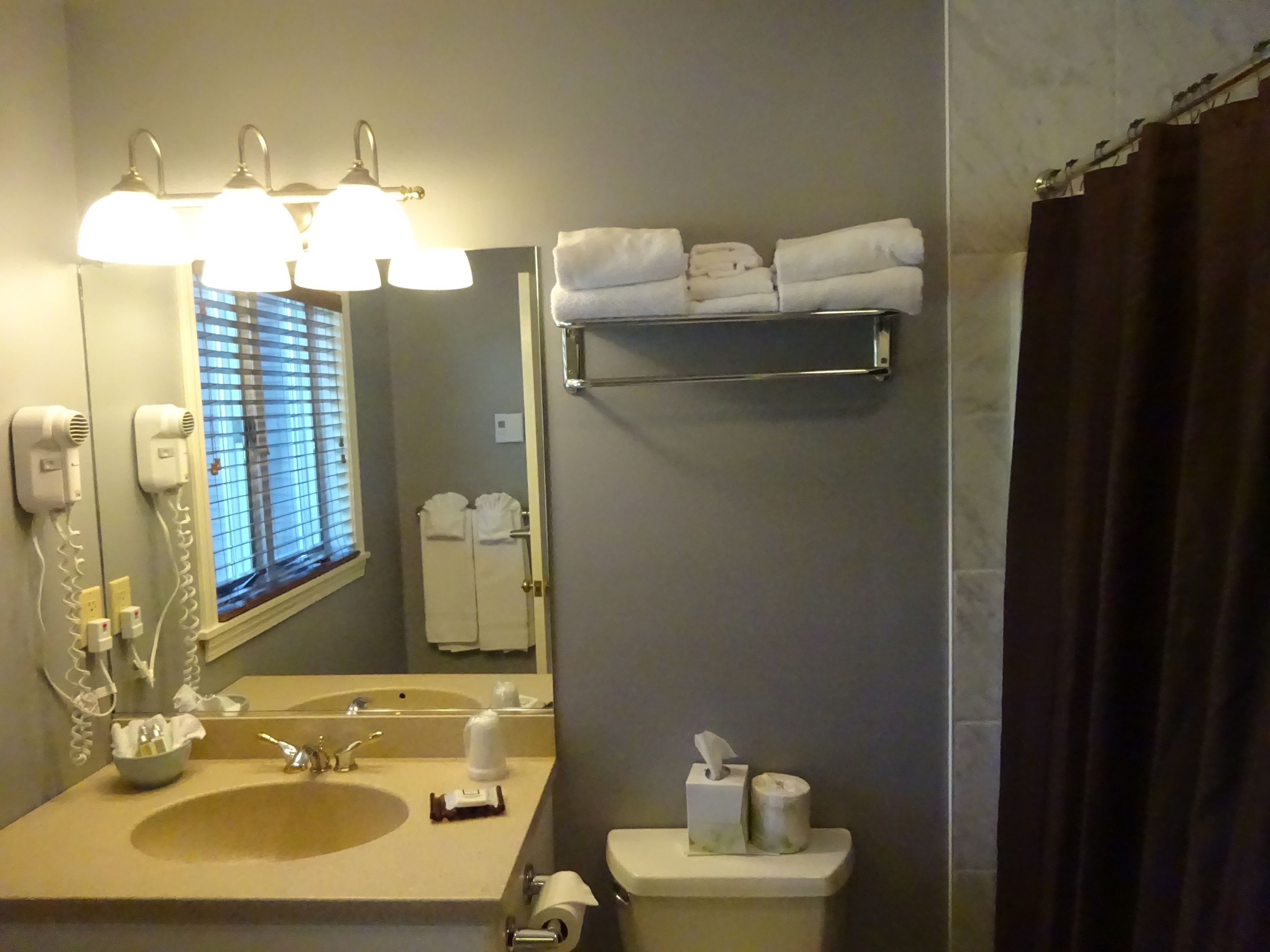 A bathroom with a sink, mirror, towel rack, and toilet.