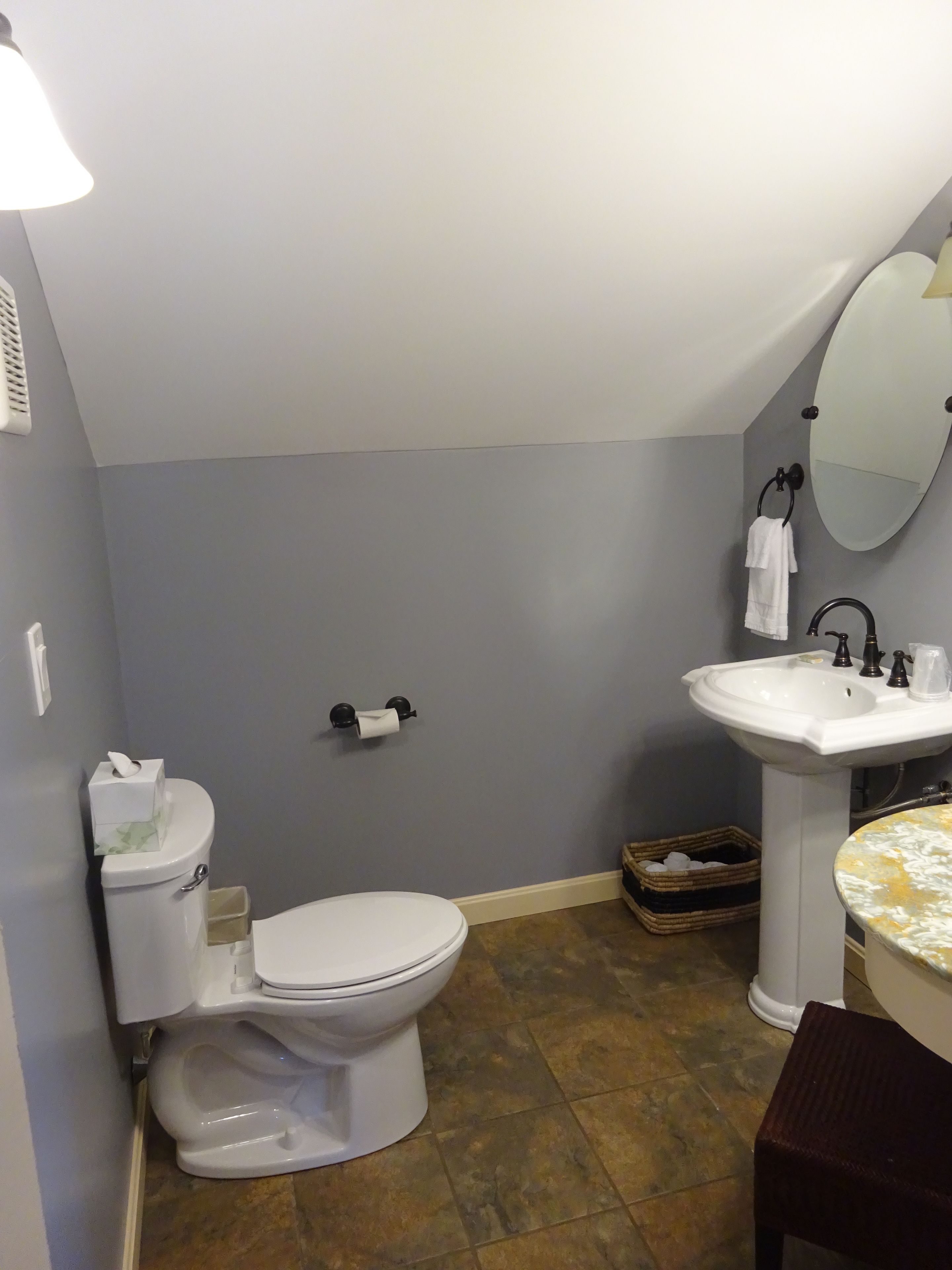 Un baño con inodoro, lavabo y espejo.