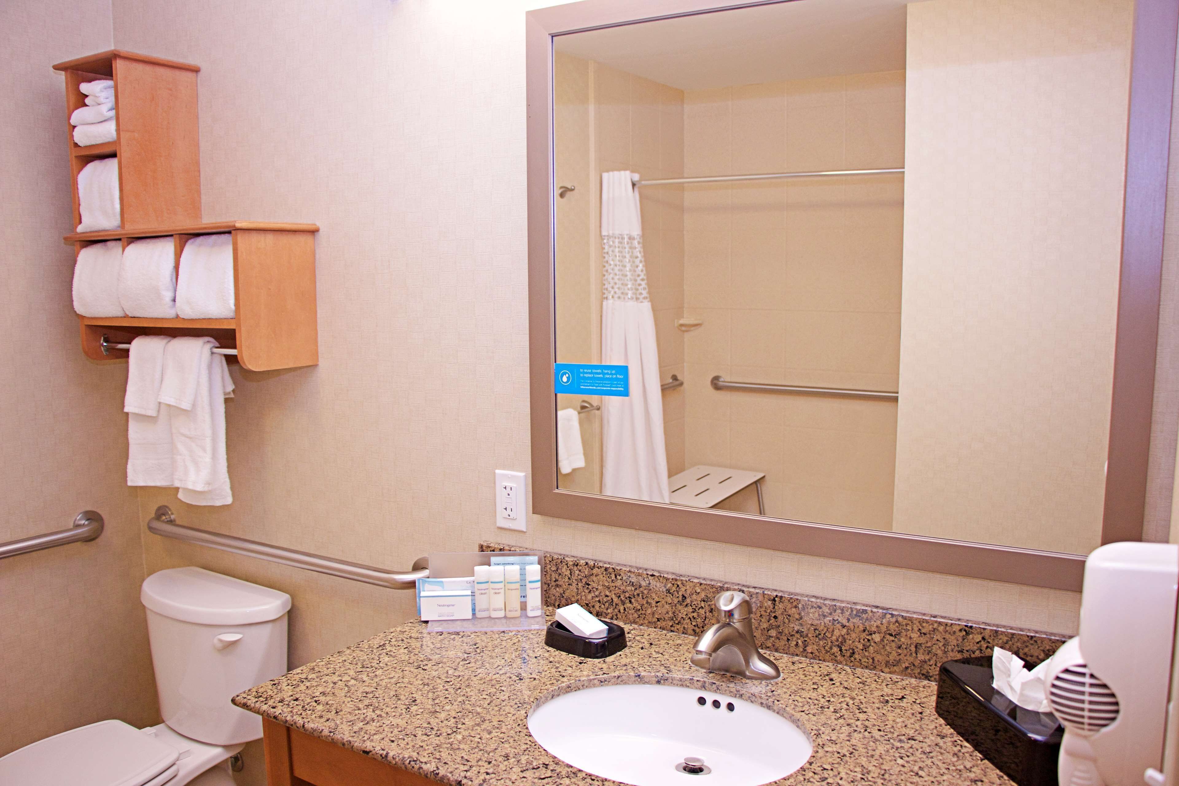 Un baño con lavabo, inodoro, toallero y espejo.