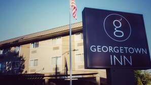A sign for Georgetown Inn with a flagpole and an American flag. - Georgetown Inn (Seattle)