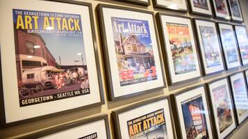 Una parete di locandine incorniciate per The Georgetown Second Saturday Art Attack, con date e luoghi indicati.