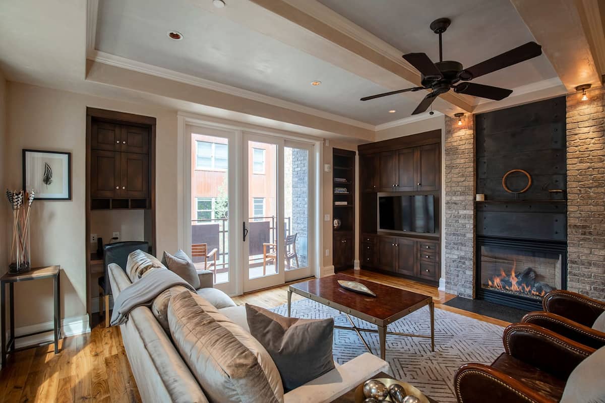 A spacious living room with a sofa, coffee table, and fireplace.