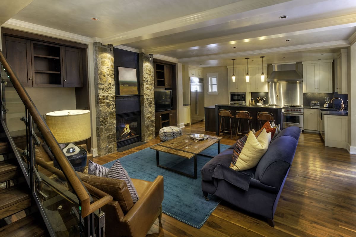 A spacious living area with a sofa, coffee table, and a fireplace.