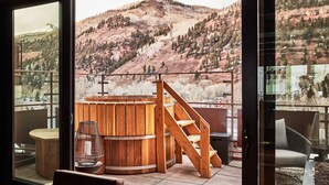 A balcony with a wooden hot tub, a wooden staircase, and a view of a mountainous landscape. - Element 52, Auberge Collection (Telluride)