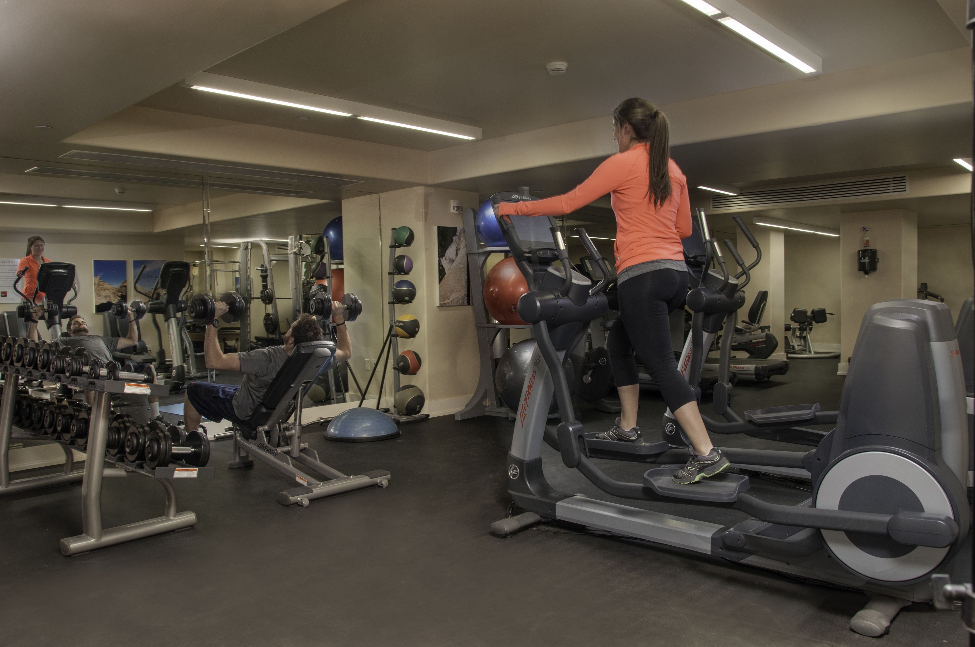 A gym with treadmills, weight machines, and exercise balls.