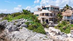A beachfront property with multiple levels, outdoor seating, and lush greenery. - La Posada del Sol Boutique Hotel Tulum (Tulum)