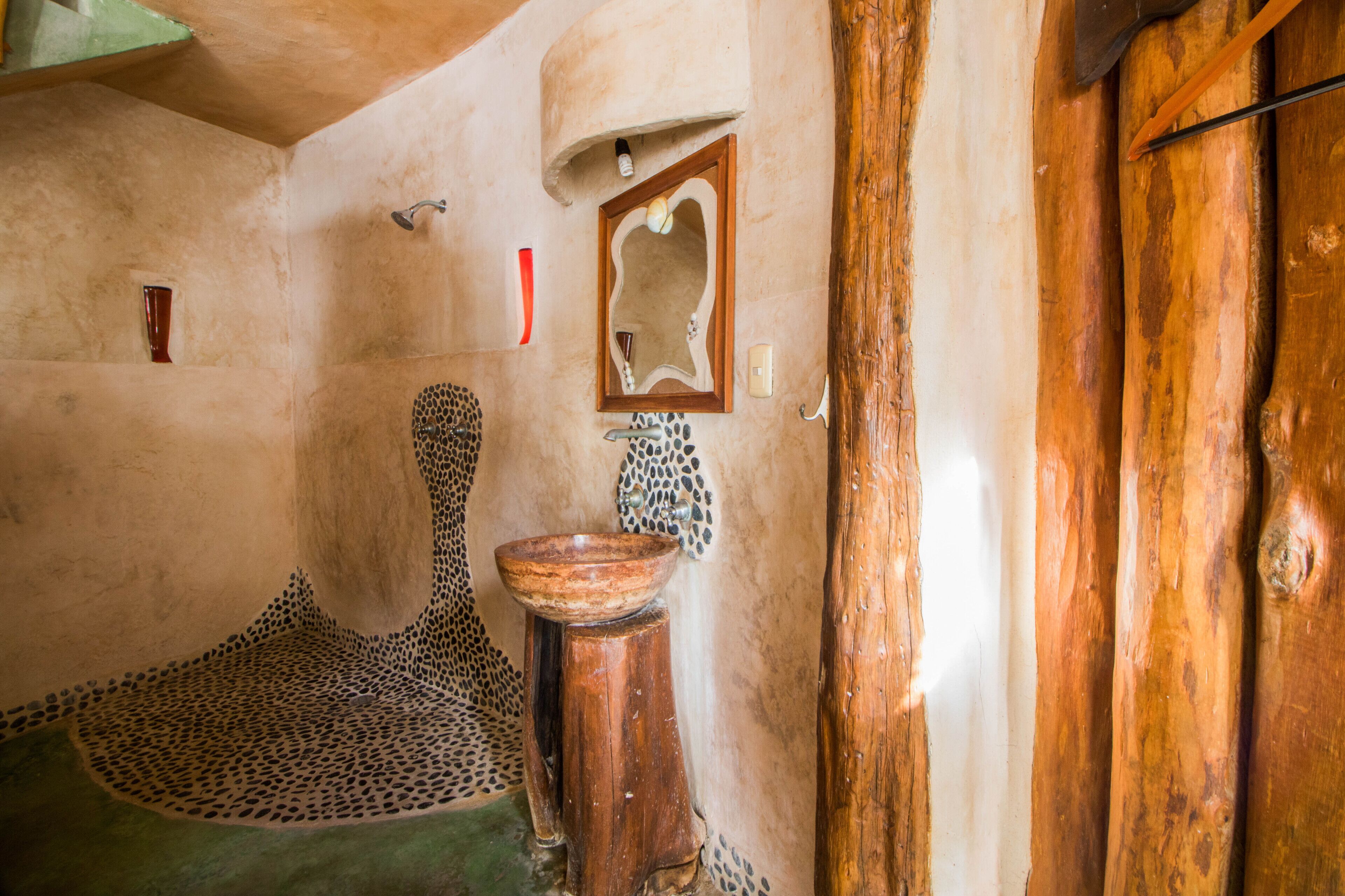 A rustic bathroom with a wooden basin, a mirror, and a leopard print floor.