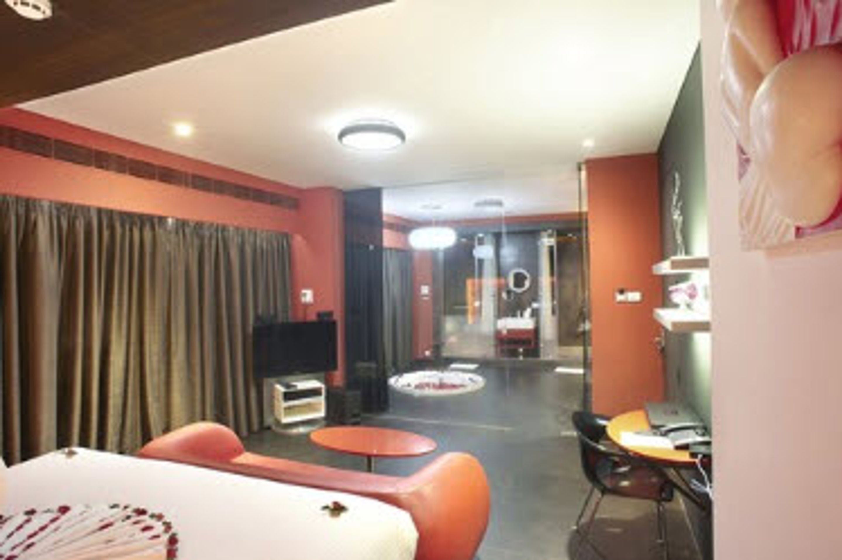 Una habitación de hotel con una cama, televisión, escritorio y silla.