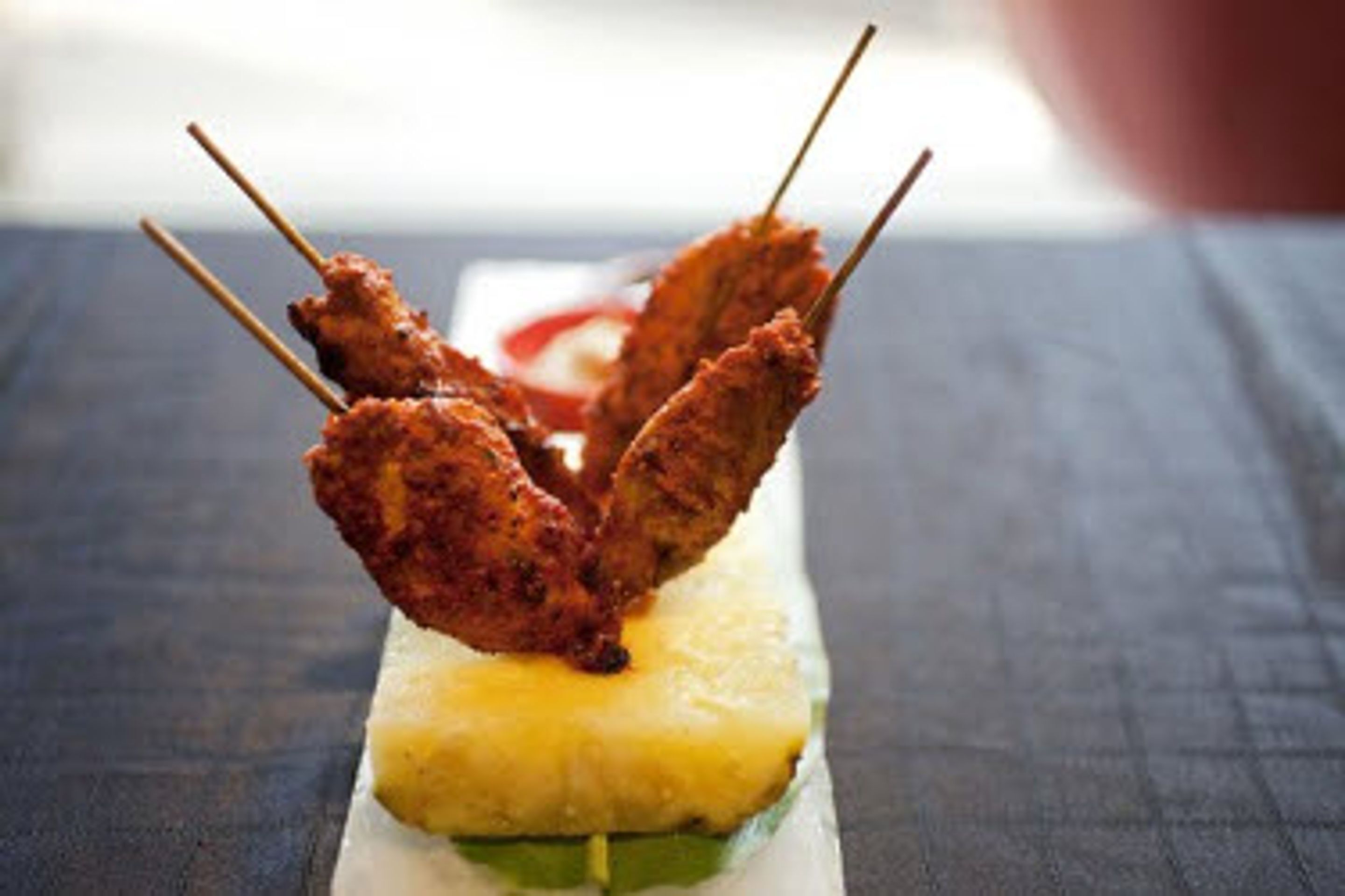 Skewers of fried food on a pineapple.