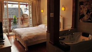 Une chambre à coucher avec un grand lit, un lustre, une vue sur un balcon et une salle de bain avec une baignoire.