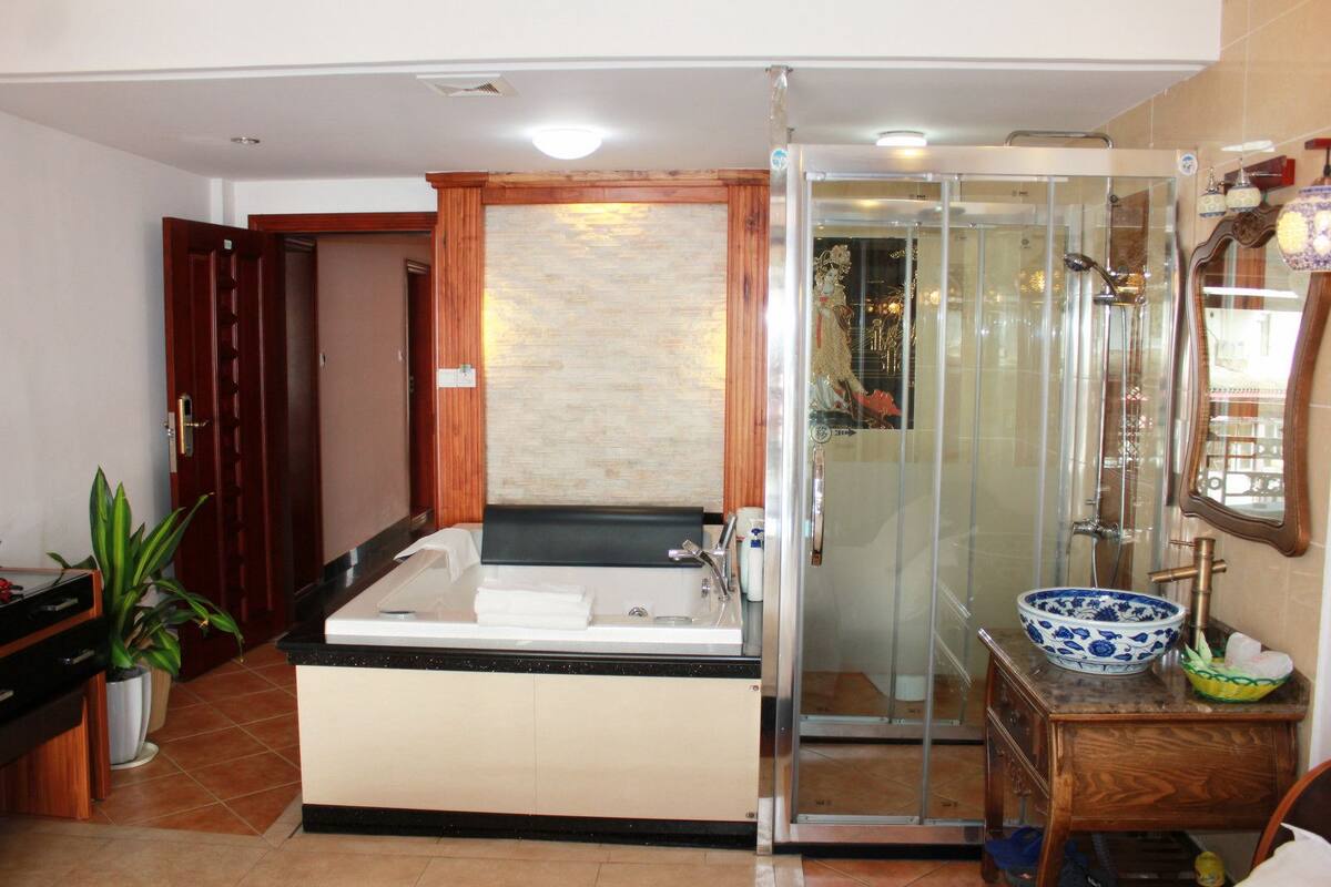 A modern bathroom with a glass-enclosed shower, a freestanding bathtub, and a vanity with a bowl sink.