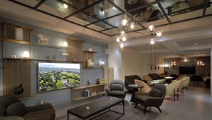 A modern living room with a large flat-screen TV, comfortable seating, and a dining area. - Hotel Klettur (Reykjavik)