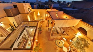 Eine Dachterrasse mit Sitzbereichen, Topfpflanzen und einer Essgruppe.